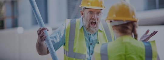 An angry construction worker yells at a colleague.